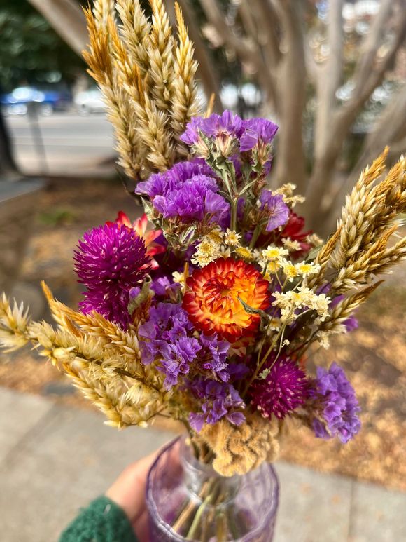 A bunch of flowers in purple vases on a table