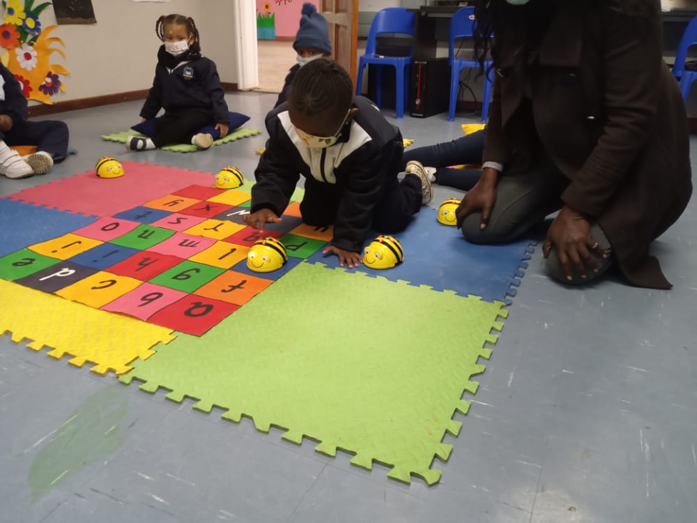 A group of children are playing a game on a puzzle mat