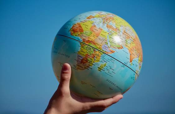 A person is holding a small globe in their hand.