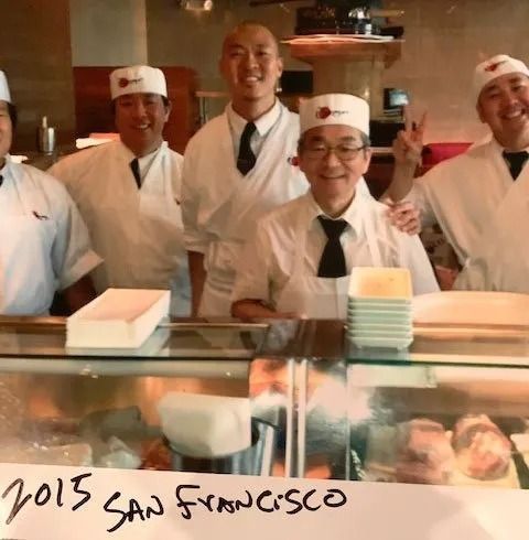 Sushi chefs in white uniforms pose behind a counter, with “2015 San Francisco” written at the bottom.