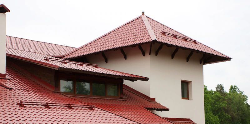 A House With a Red Tiled Roof Has Over 30 Years Experience in Roofing — Cairns Roofing Contractors Pty Ltd in Bungalow, QLD