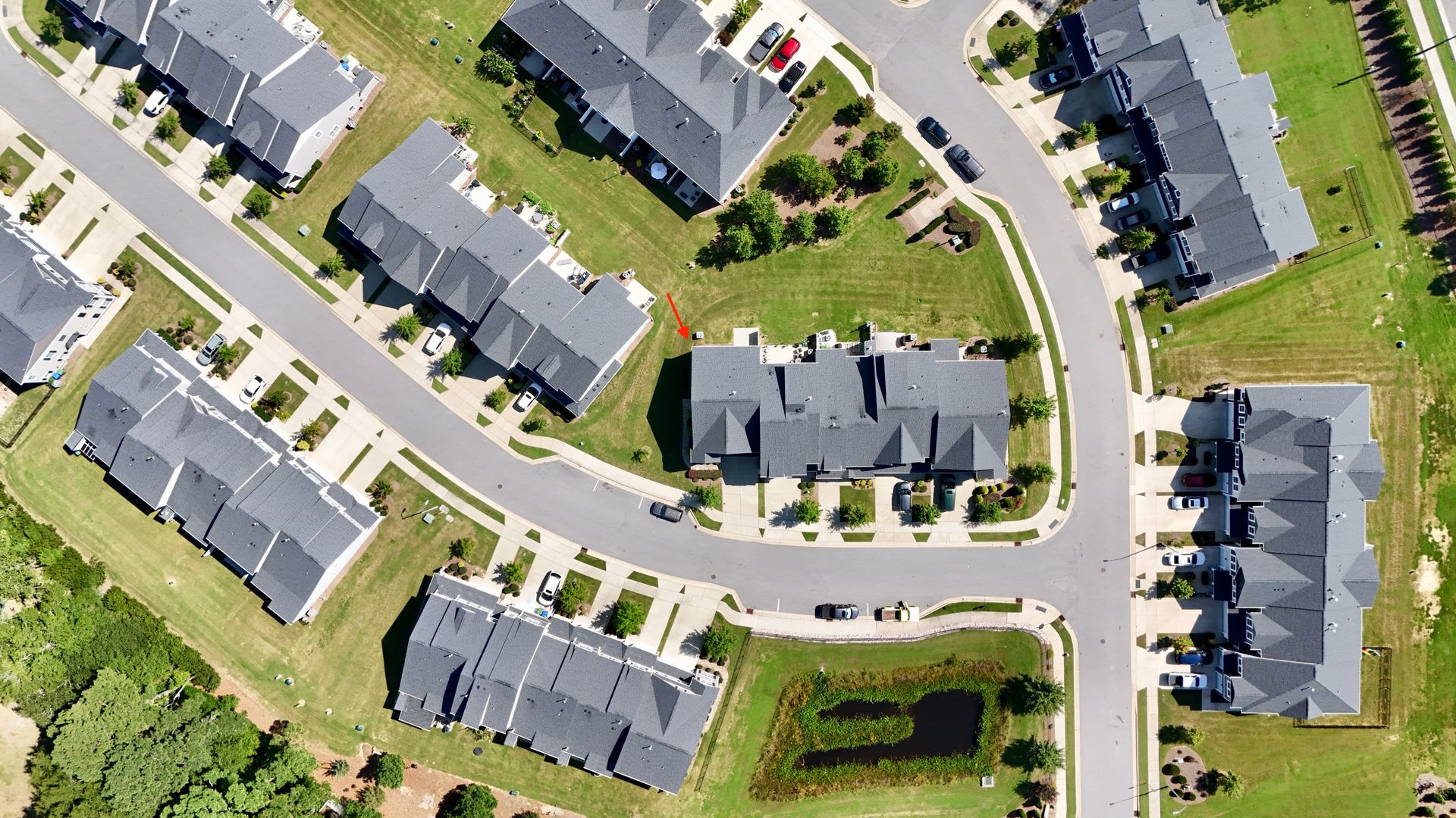 Aerial view of a residential neighborhood with townhouses, streets, and green space.