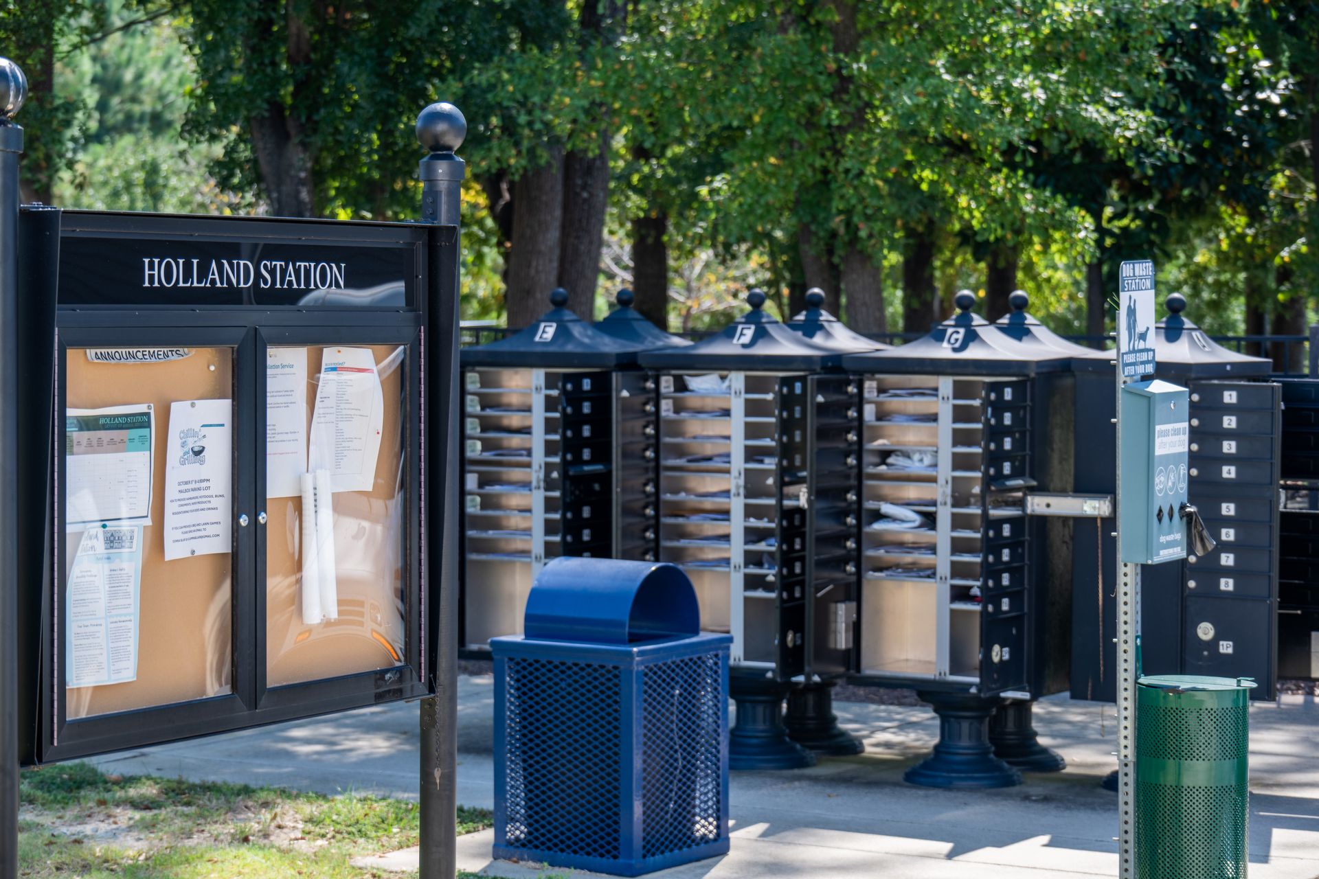 Holland Station park with mailboxes, bulletin board, and trash cans.