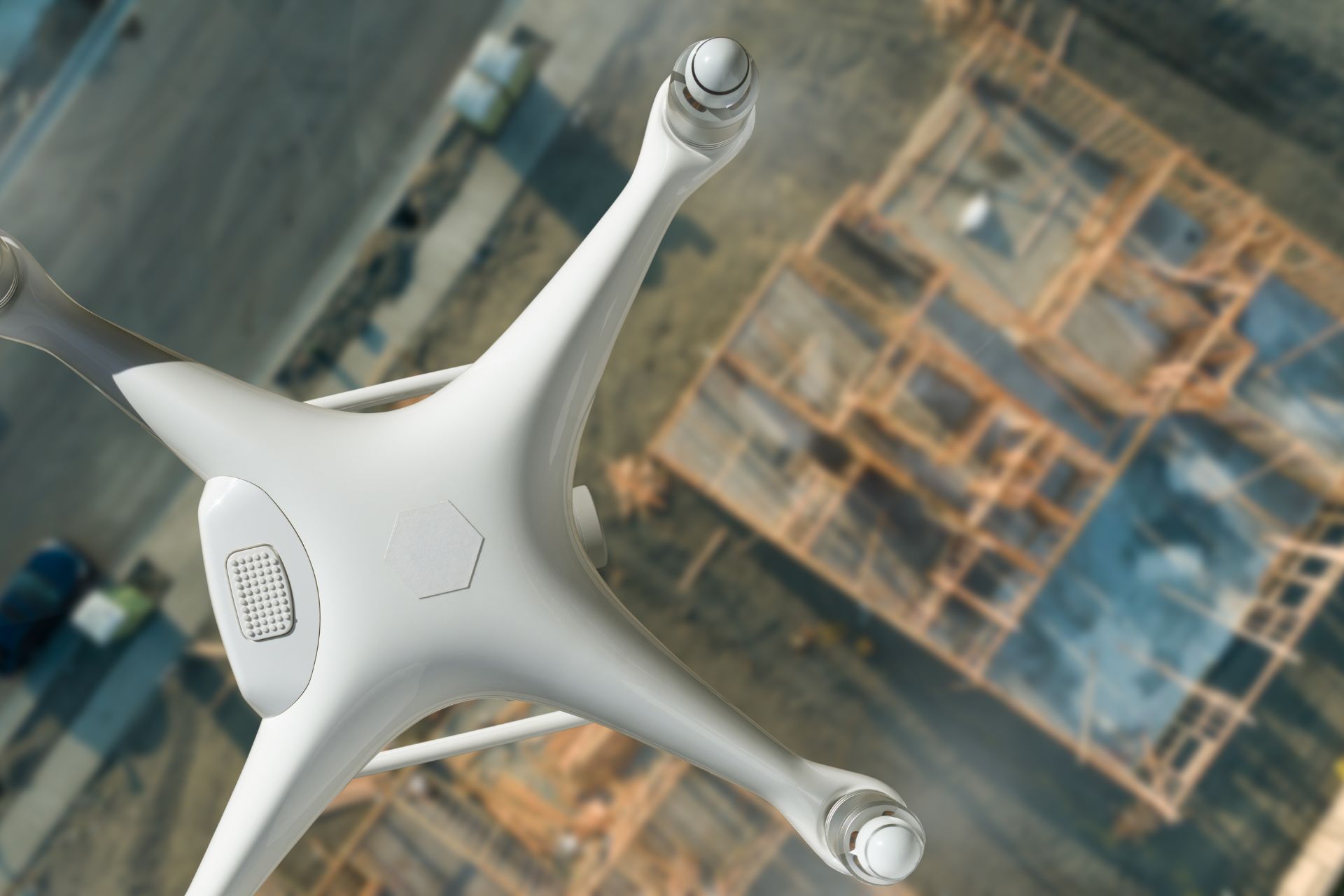 White drone flying over a construction site, aerial view.
