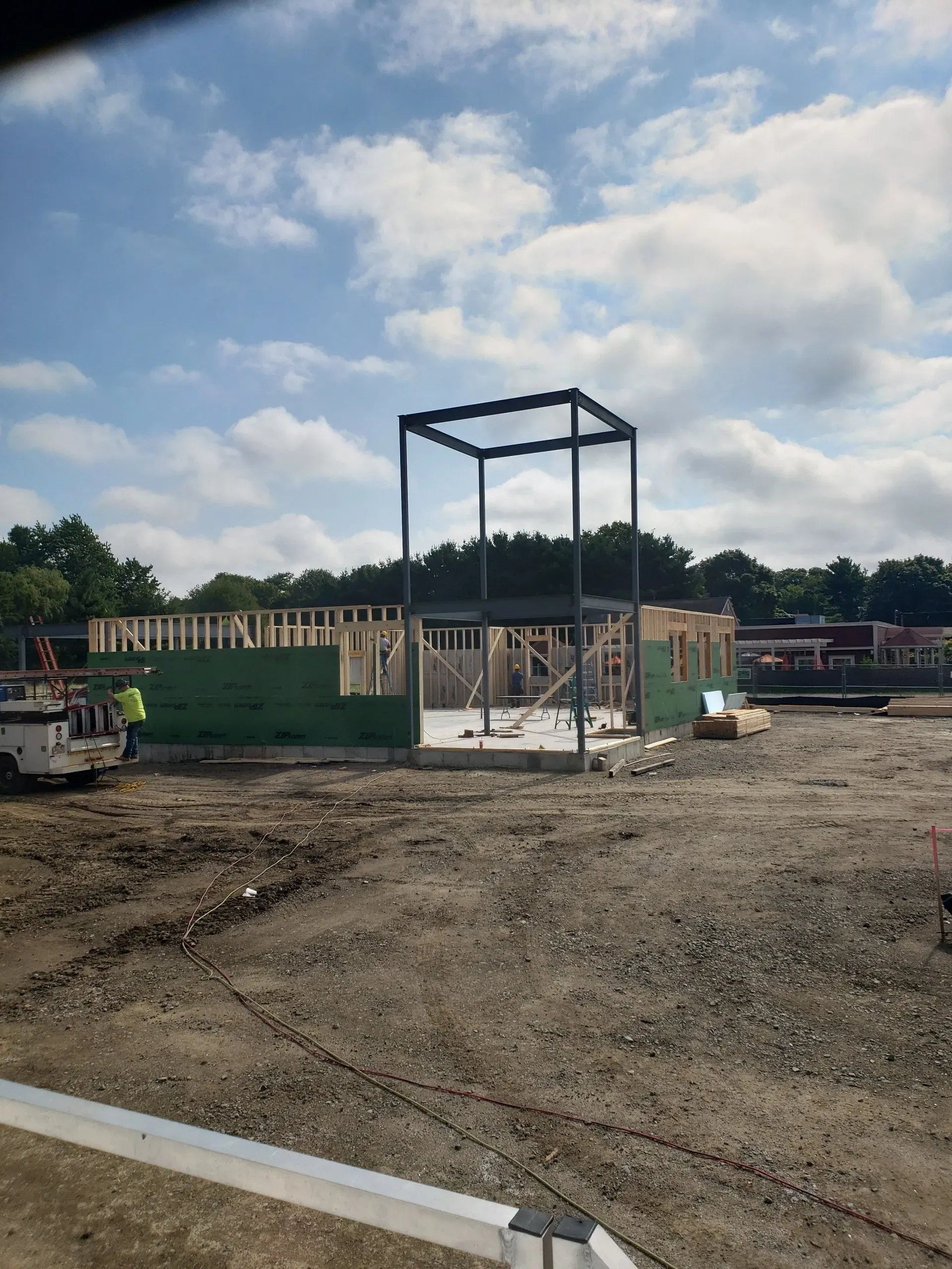 A large building is being built in a dirt field.