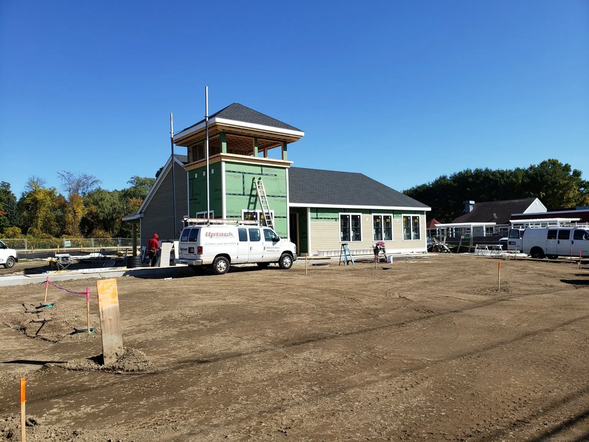 A white van is parked in front of a house under construction