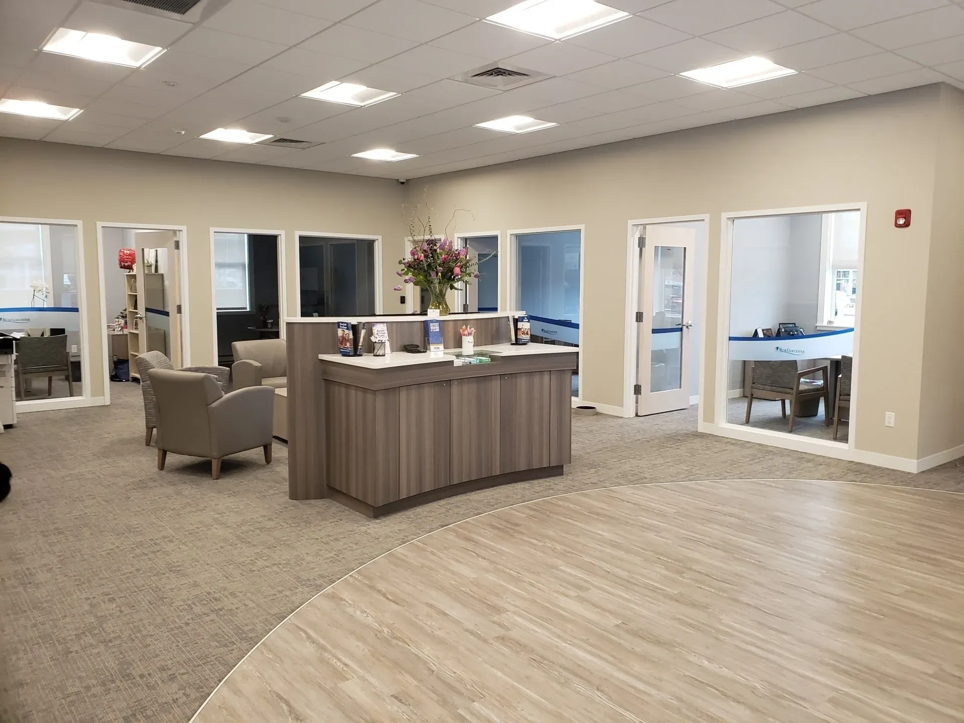 A large room with a reception desk and chairs in it.