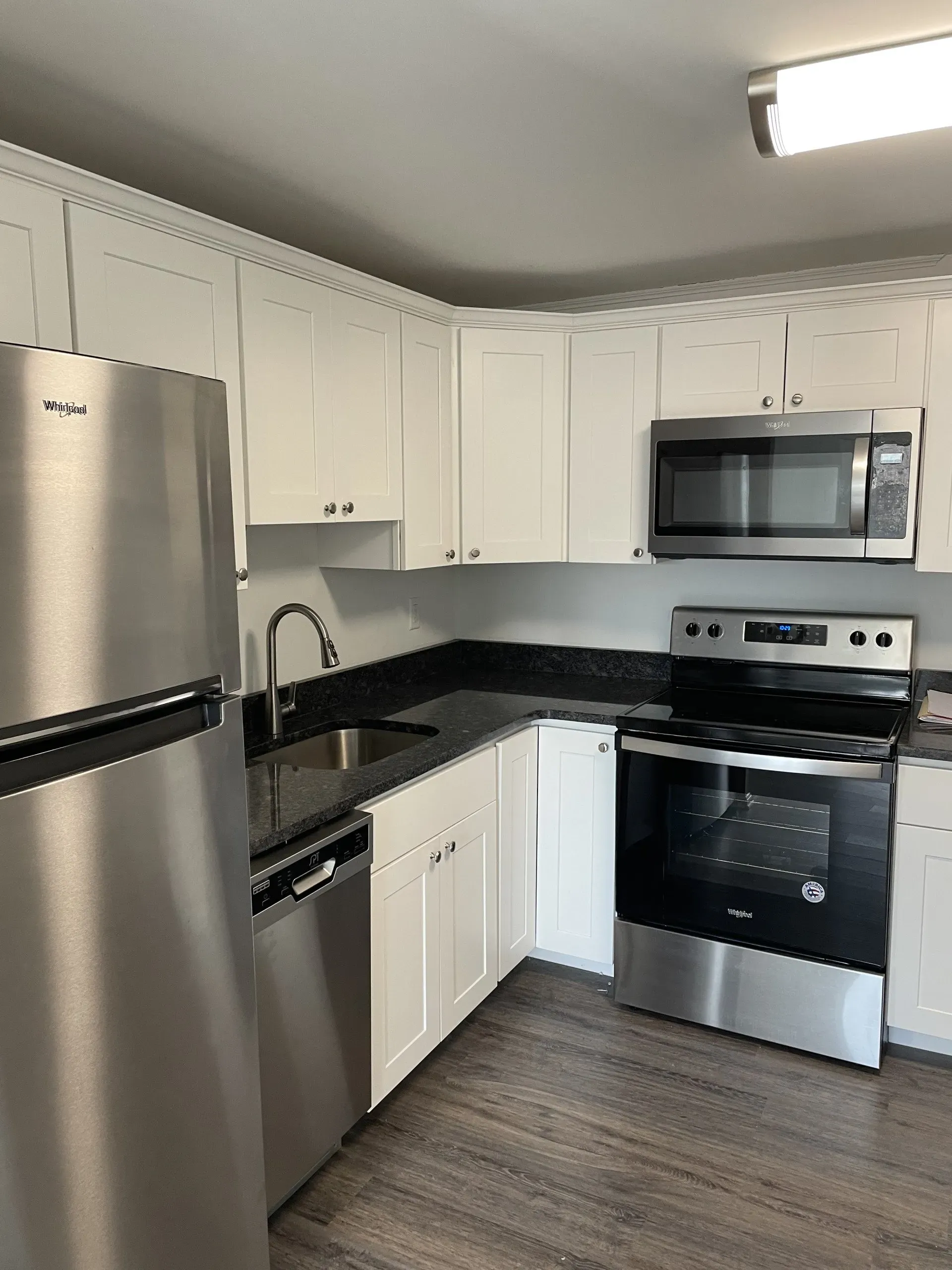 A kitchen with stainless steel appliances and white cabinets