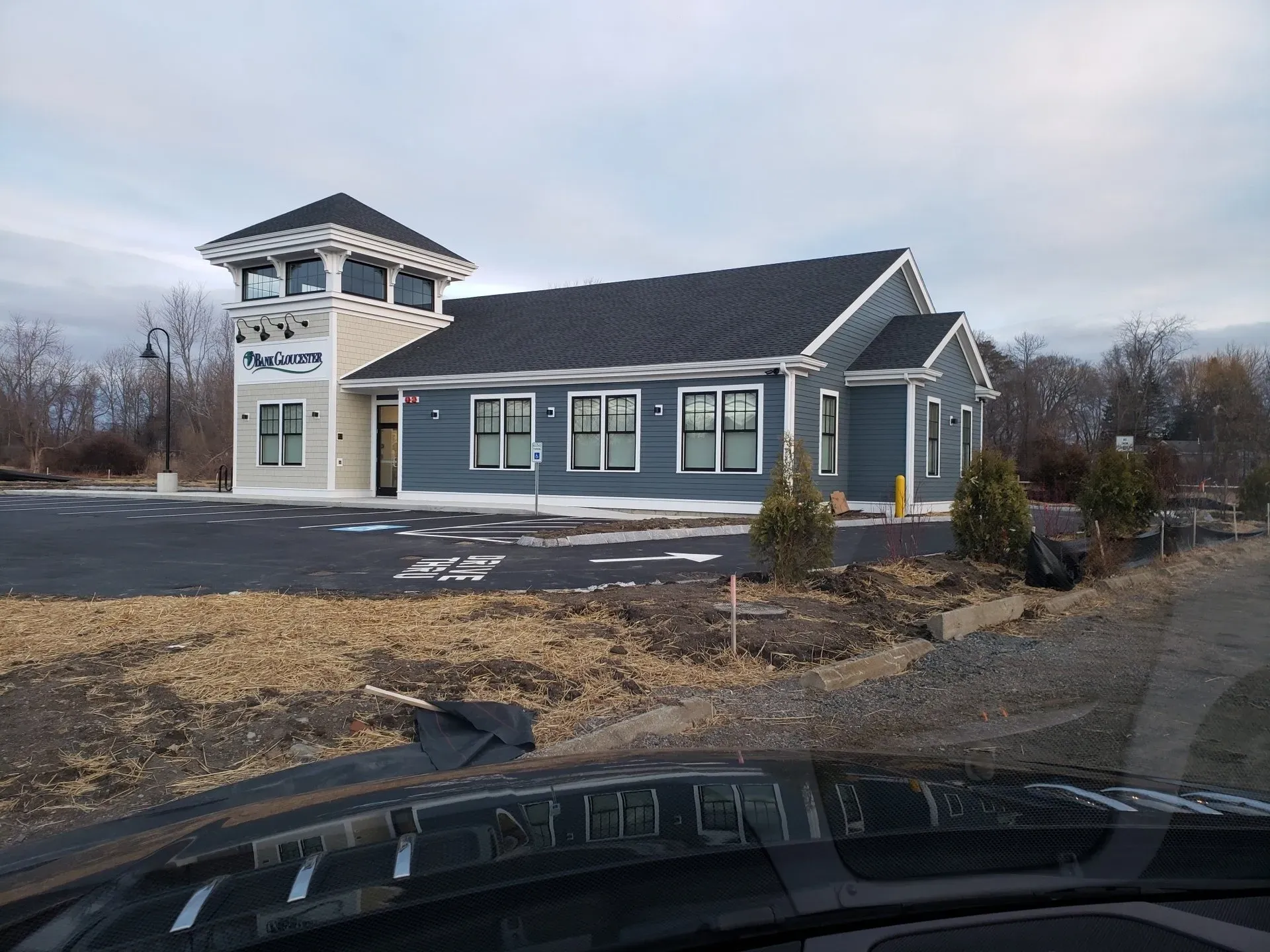 A large building with a lot of windows is sitting on the side of the road.