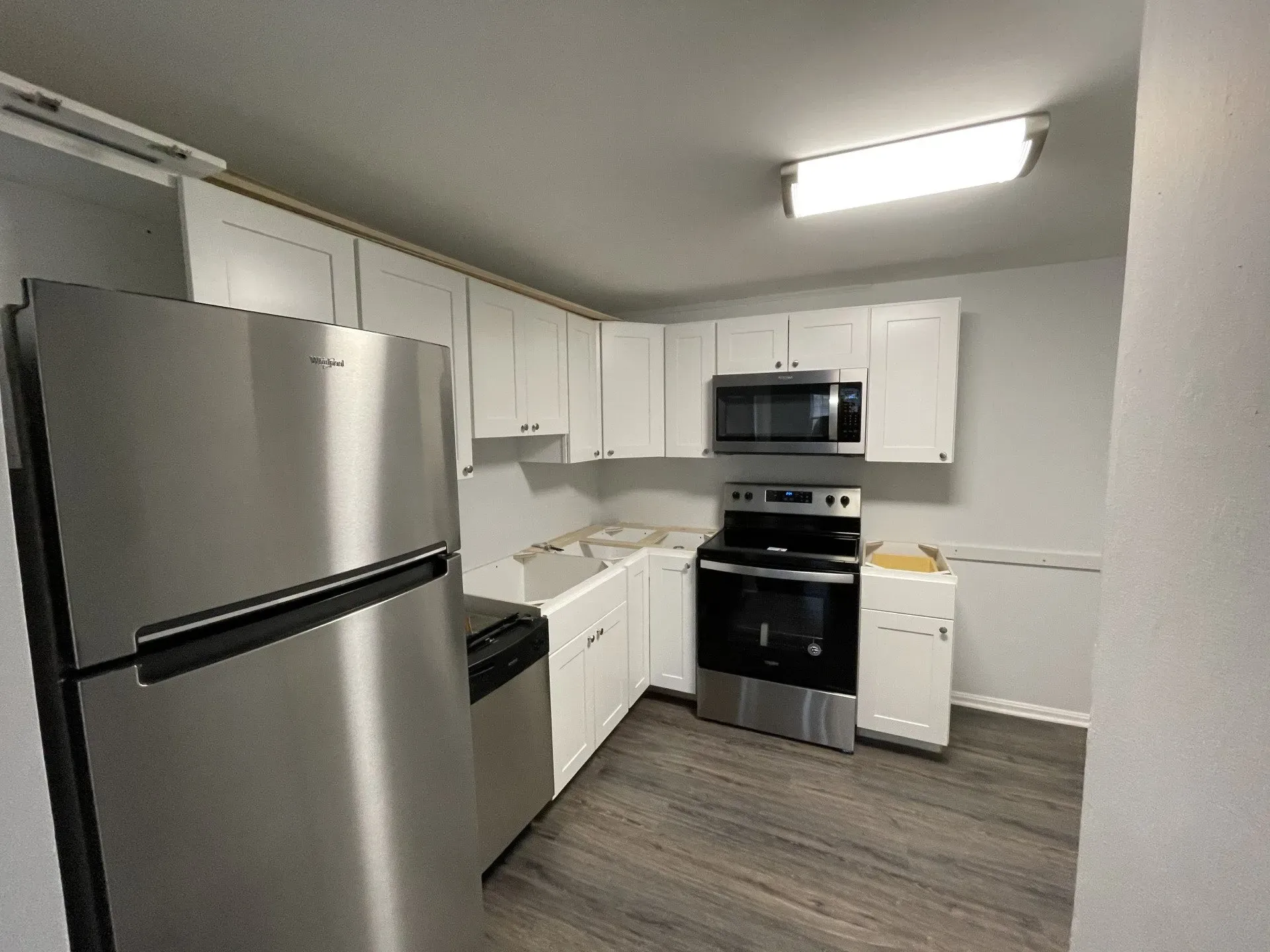 A kitchen with stainless steel appliances and white cabinets