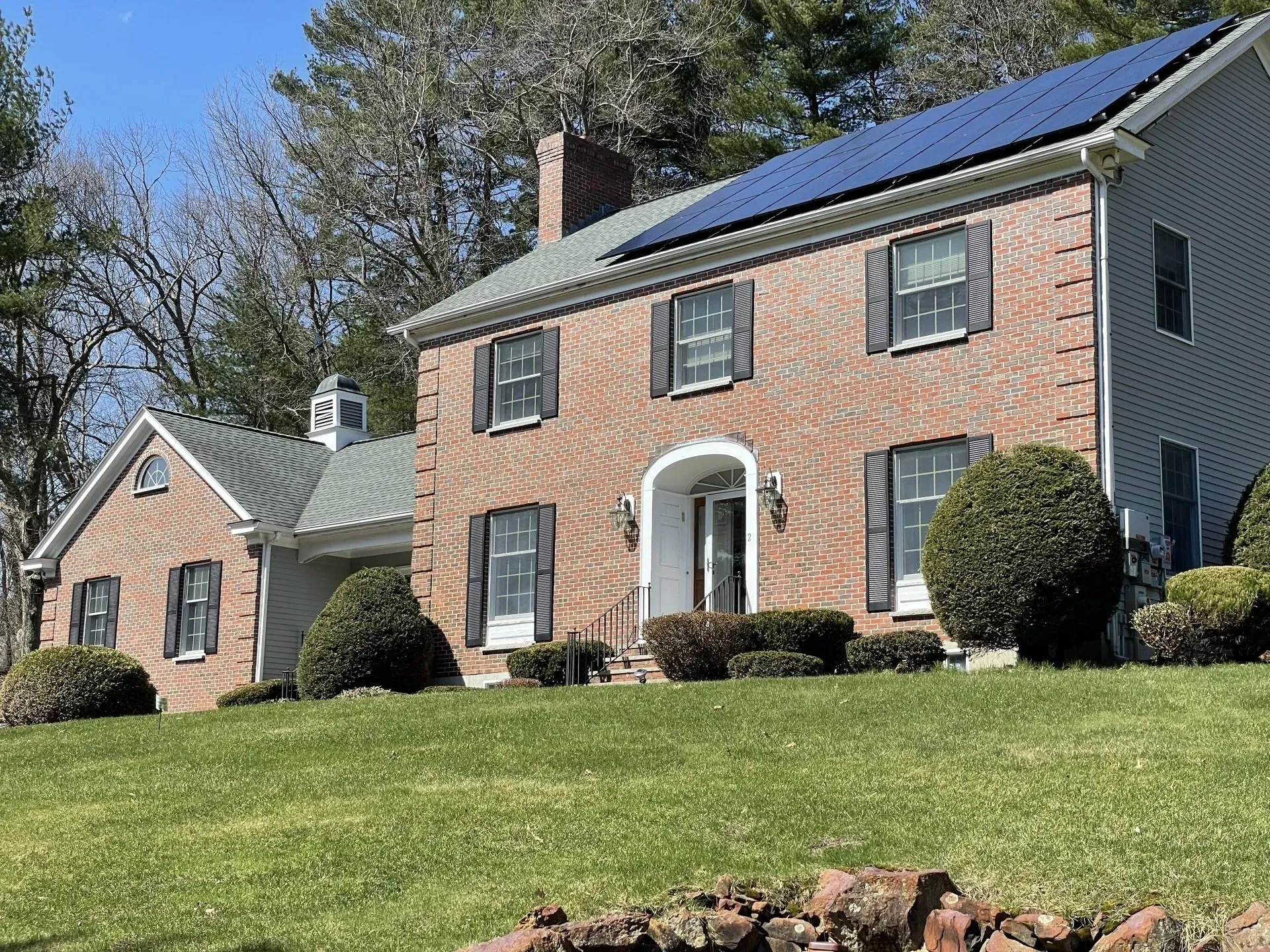 A large brick house with solar panels on the roof.