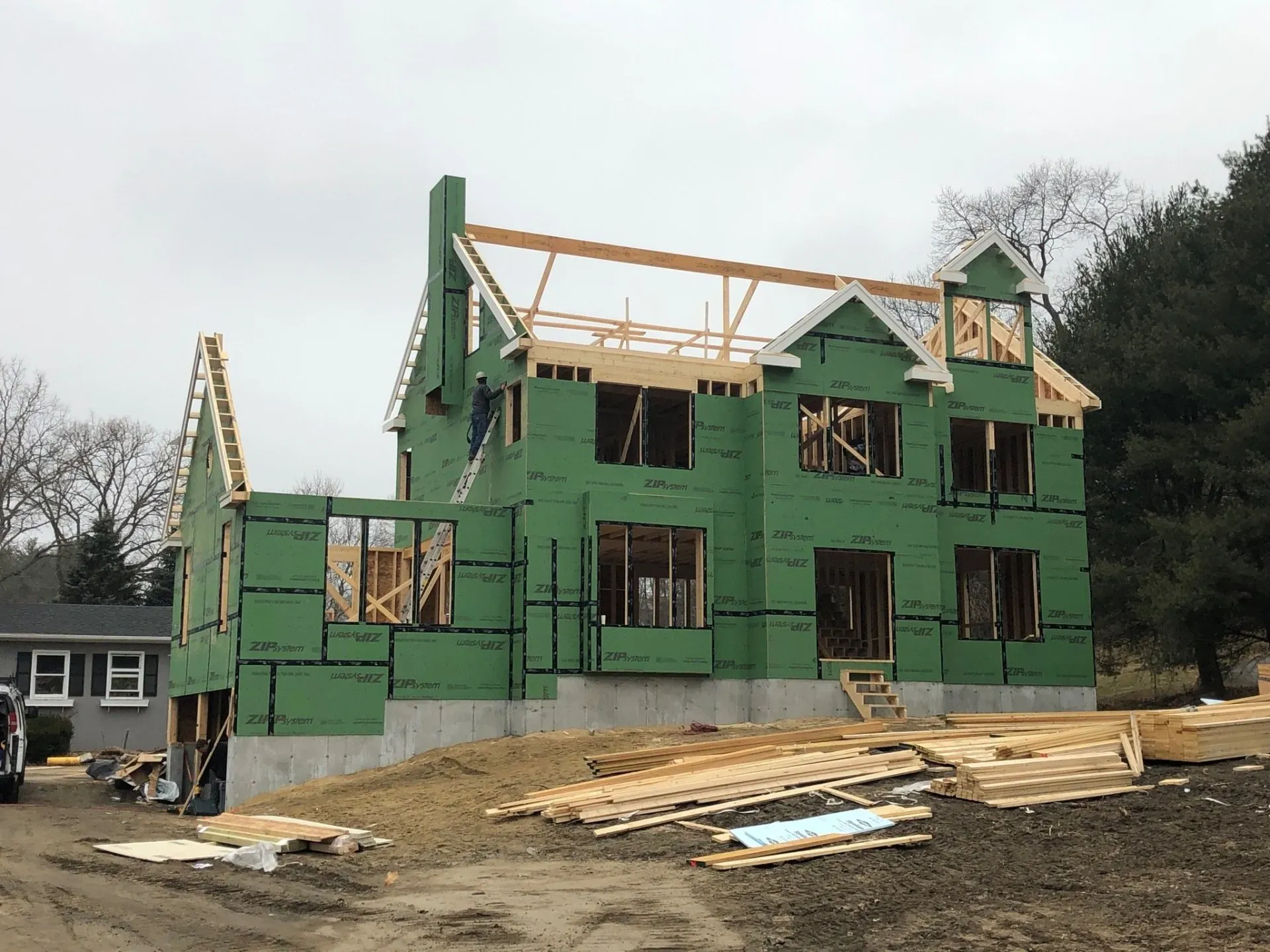 A large house is being built in the middle of a dirt field.