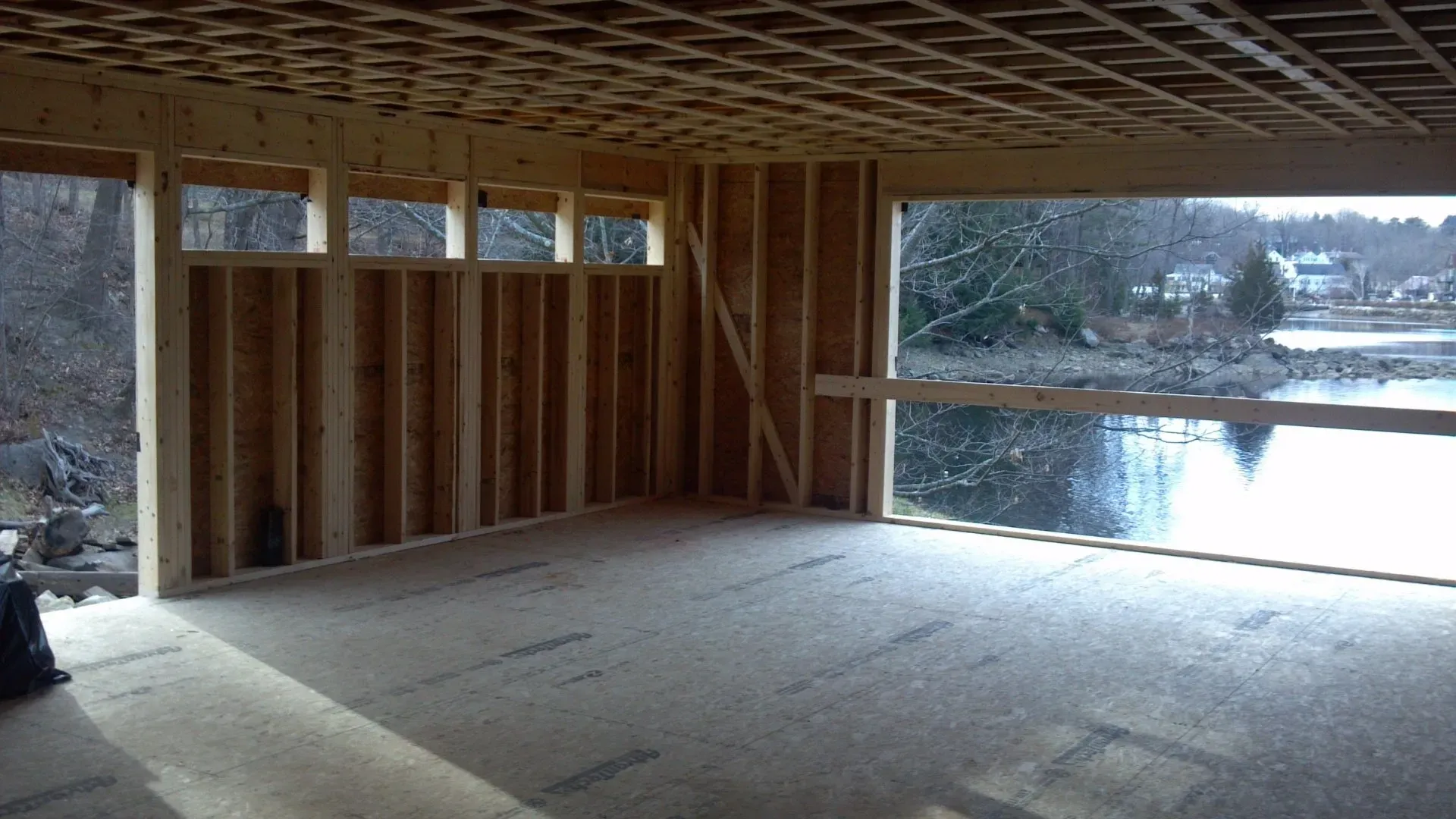 An empty room with a large window overlooking a lake.
