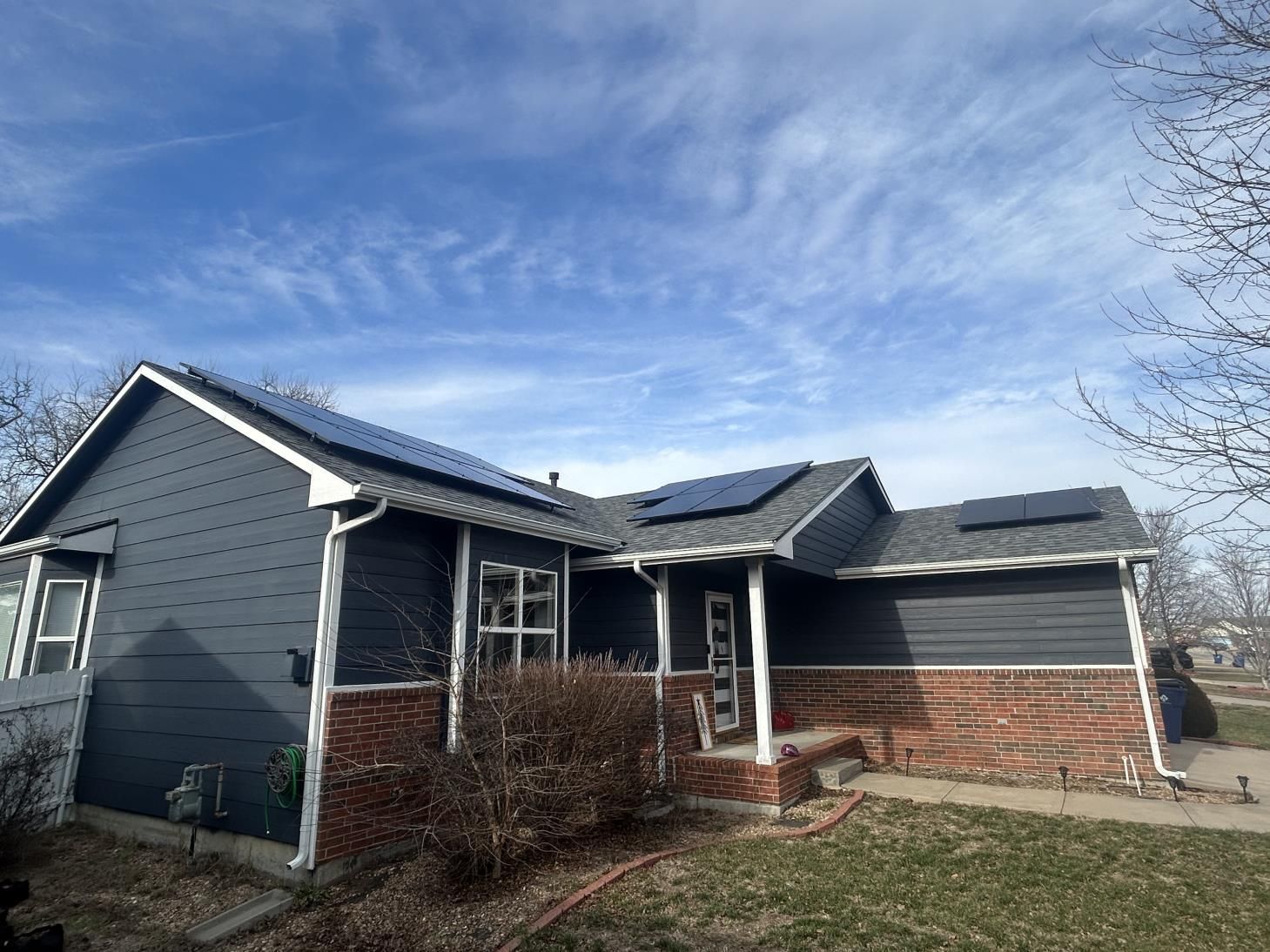 Solar panels installed on the rooftop of a charming brick house, harnessing renewable energy from the sun to power the home.