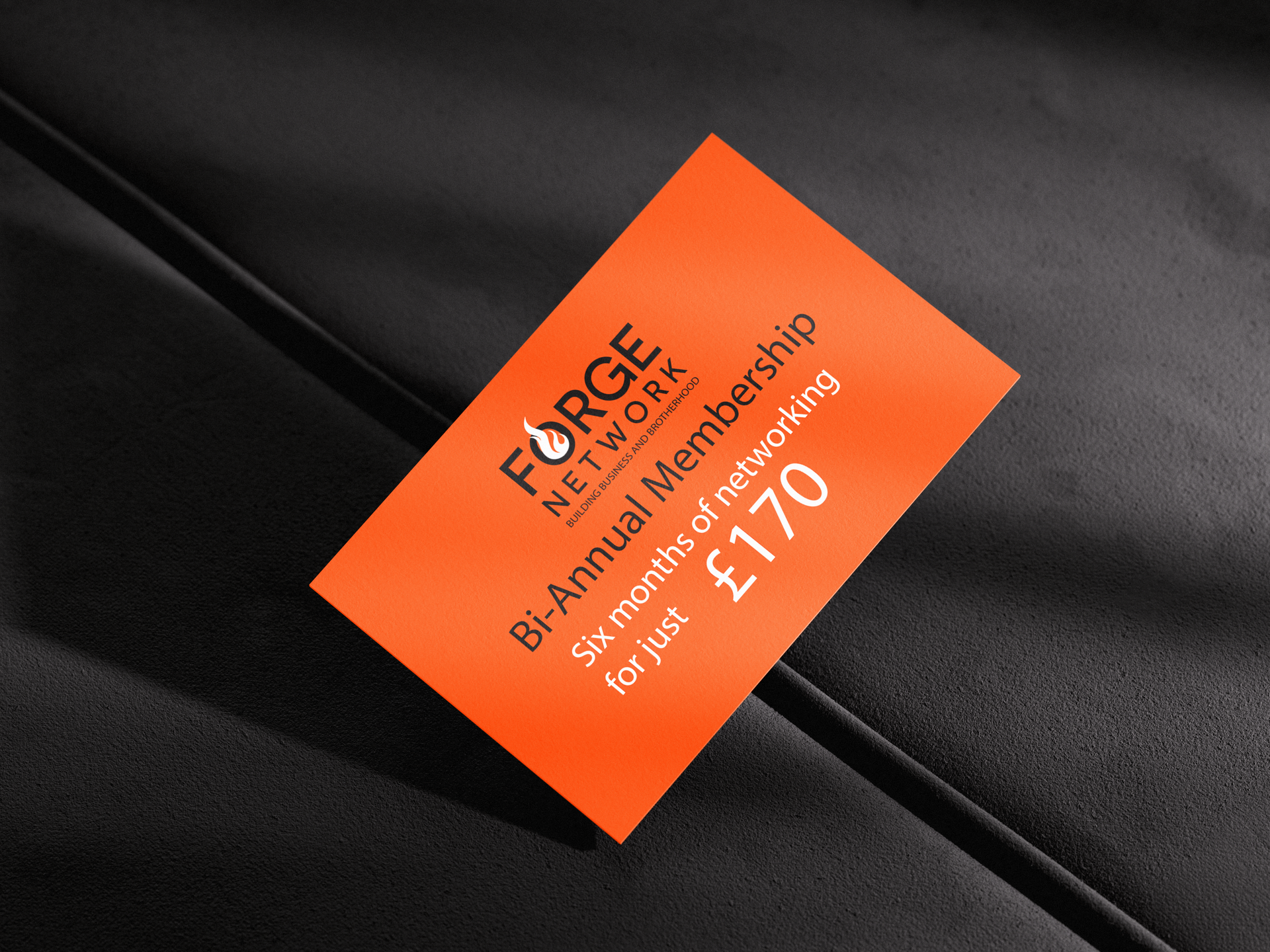 Orange tag with text for Forge Network bi-annual membership for £170 on a black surface.