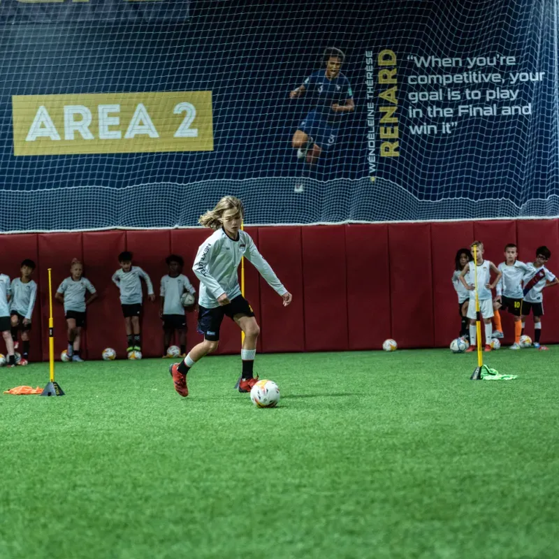 A group of children are playing soccer in area 2