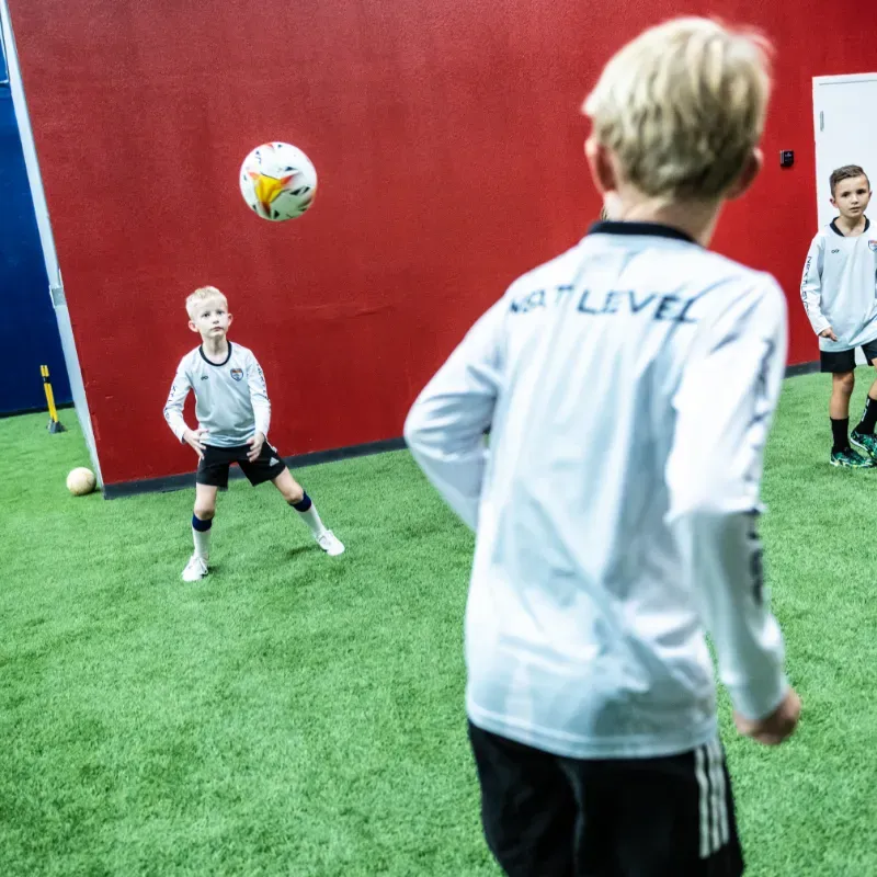 A boy wearing a white shirt with the word level on the back