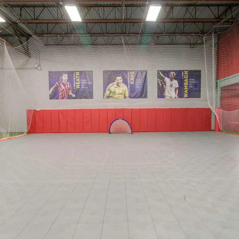 A large indoor soccer field with posters on the wall.