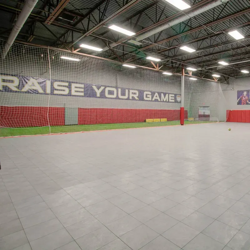 An empty gym with a sign that says raise your game
