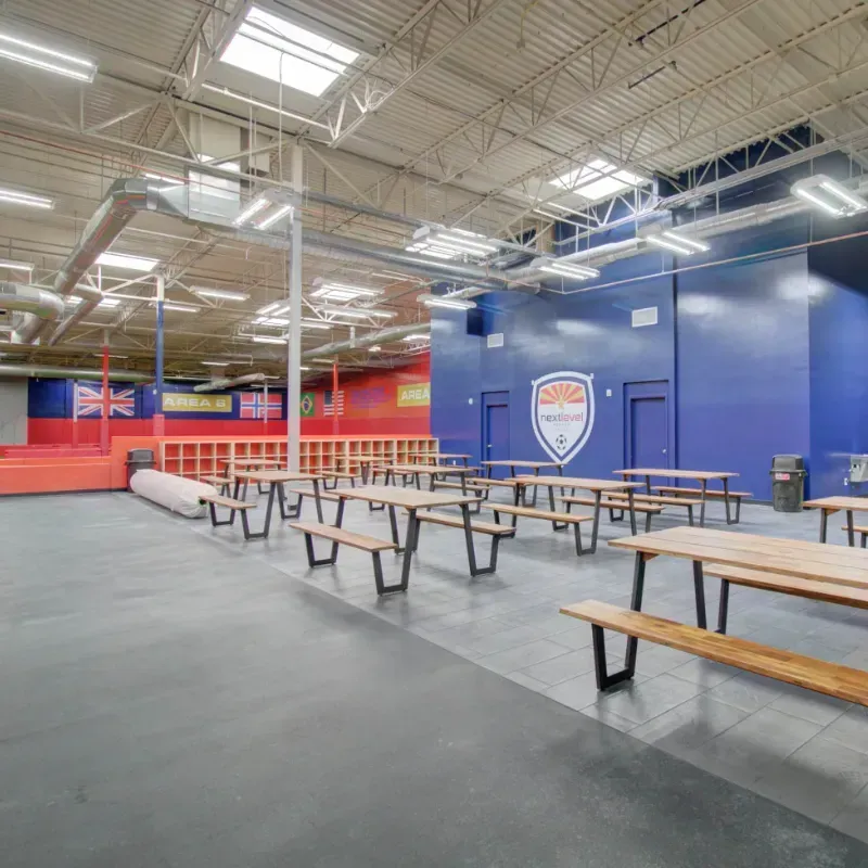 A large room with lots of picnic tables and benches