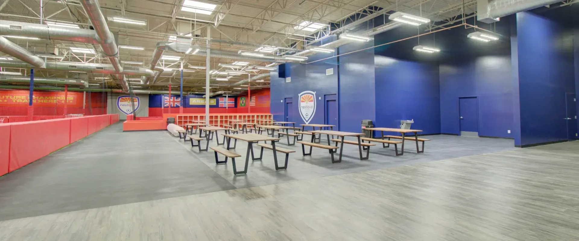 A large empty room with tables and benches in it.