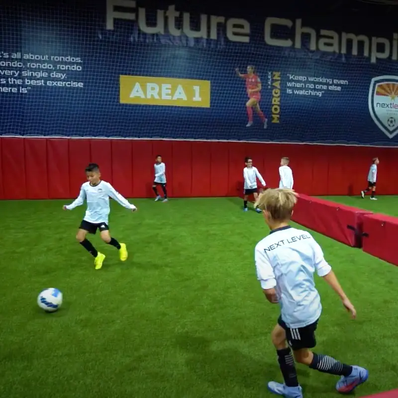 A group of young boys are playing soccer in area 1