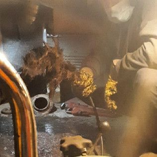 Person working on a clogged drain. A mass of hair and debris is pulled from a pipe.