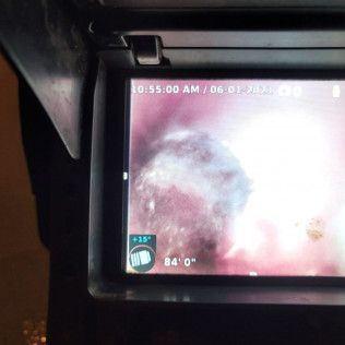 Screen displaying a blurry, pink and white swirling cloud-like image with digital information on the screen.