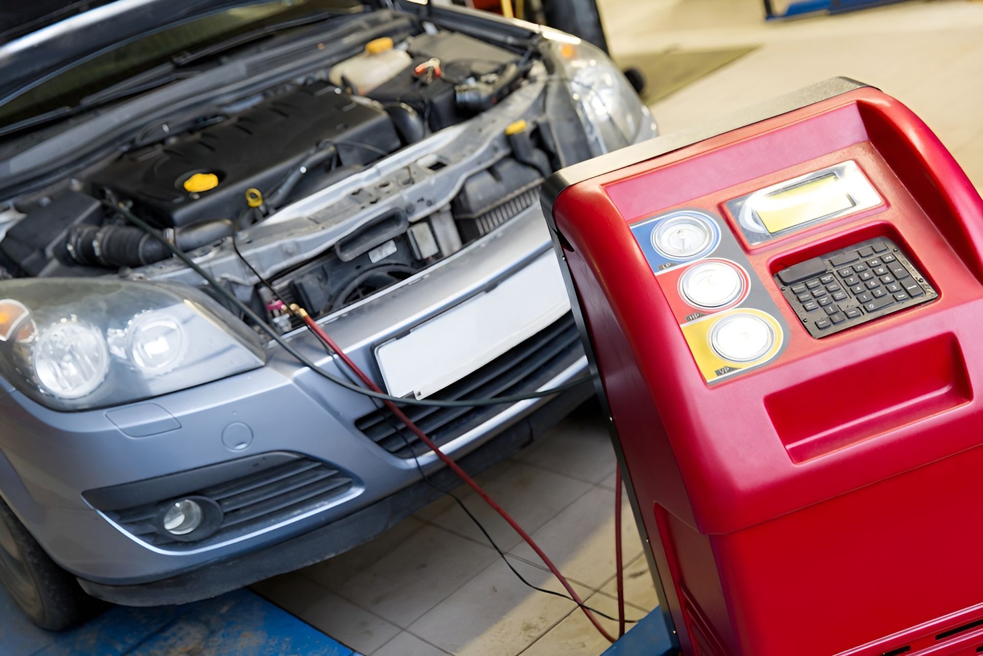 A Gray Car with Its Hood Open Connected to A Red Machine in A Garage — Morisset Automotive in Morisset, NSW