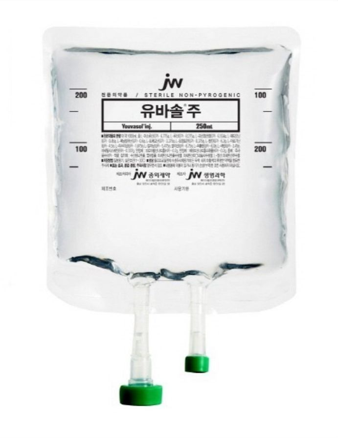 Clear IV fluid bag labeled in Korean, with two bottom ports and green caps