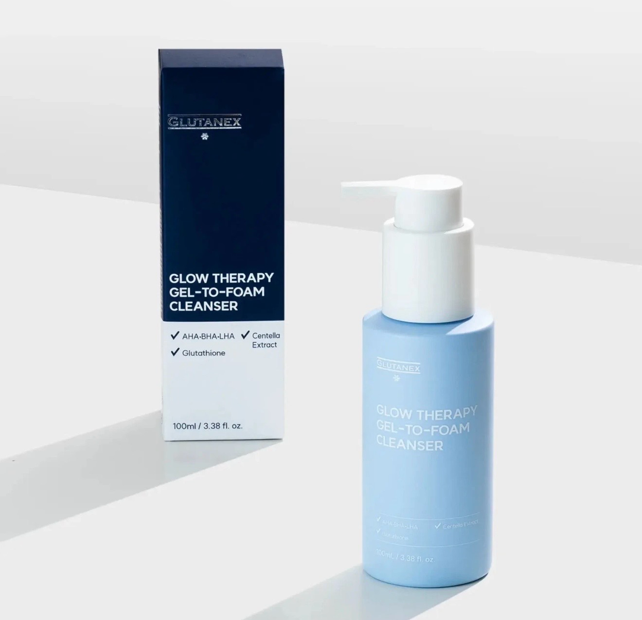 Blue-and-white Glow Therapy cleansing bottle beside matching box on a light background