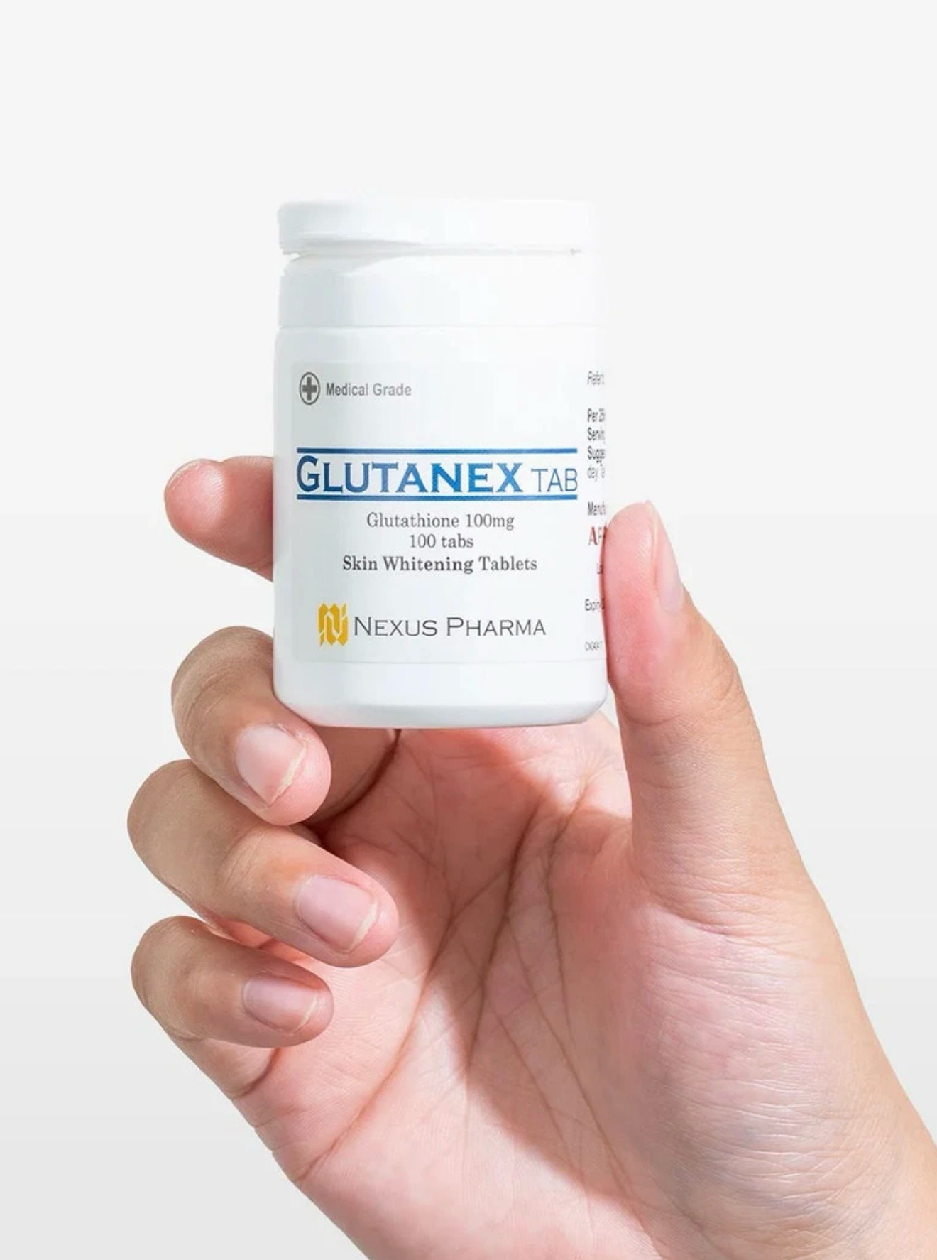 Hand holding a small white pill bottle labeled “GLUTANEX” on a plain light background