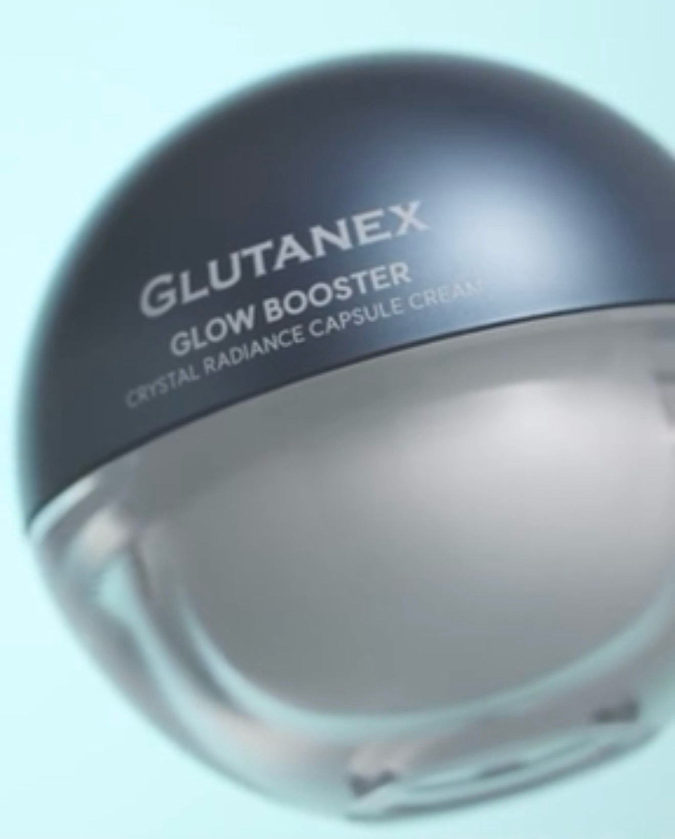 Glutanex Glow Booster crystal radiance capsule jar, silver and clear cosmetic container on a pale blue background