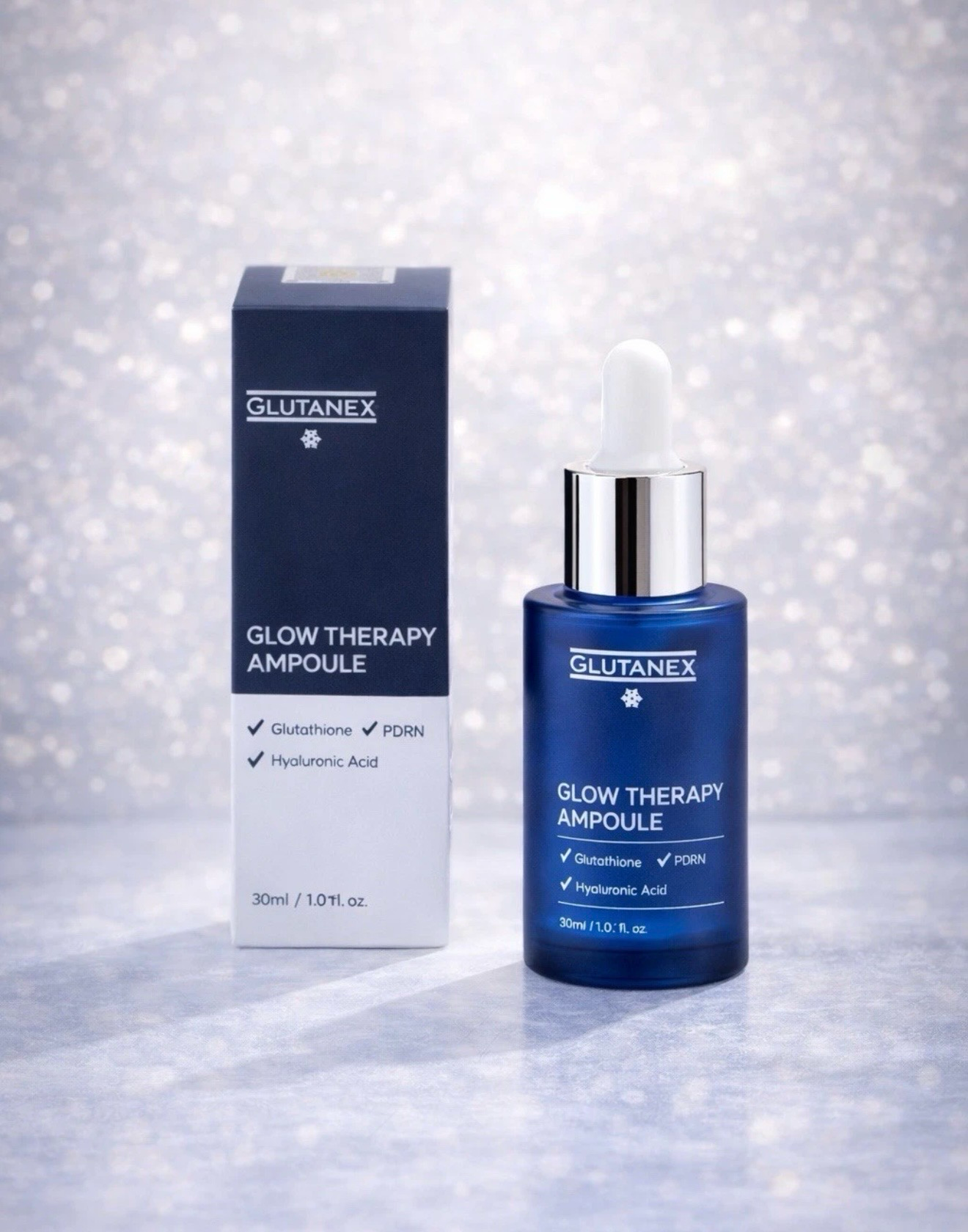 Blue skincare serum bottle and matching box on a sparkling white background