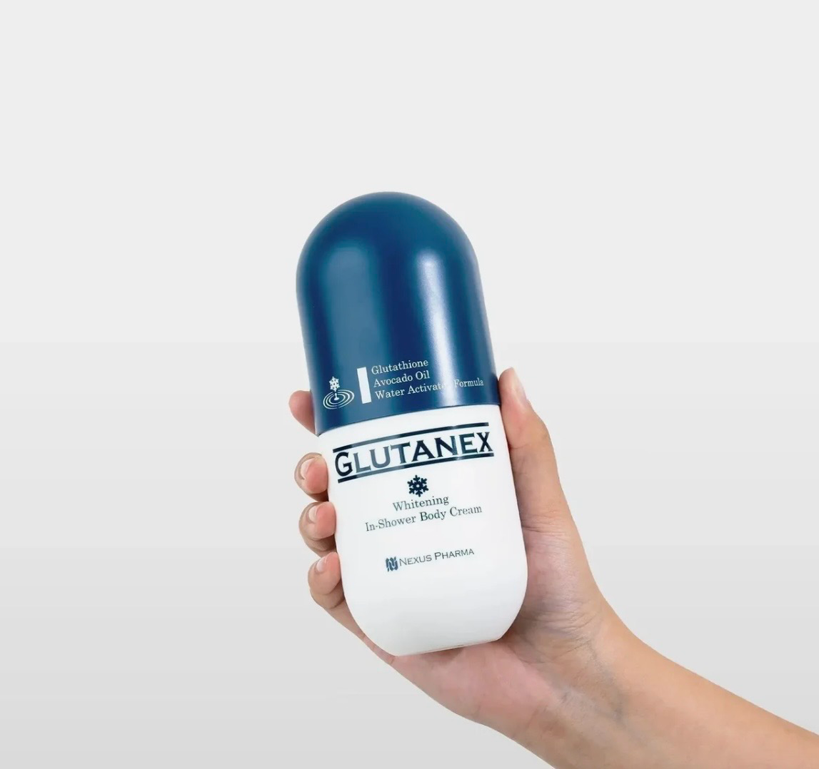 Hand holding a blue-and-white Glutanex capsule-shaped product on a white background