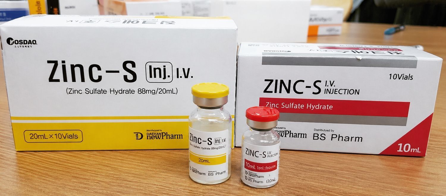 Zinc-S medication boxes and two small vials arranged on a table with a yellow and white color scheme