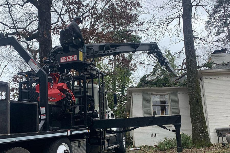 A truck with a crane attached to it is parked in front of a house.