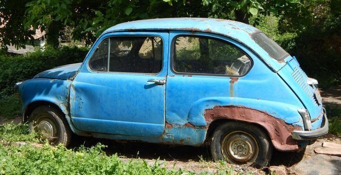 Old blue abandoned rusted car