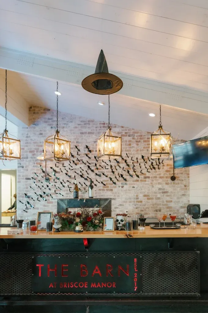 Bar with decorative lighting and a witch hat; brick wall with bat decorations. 