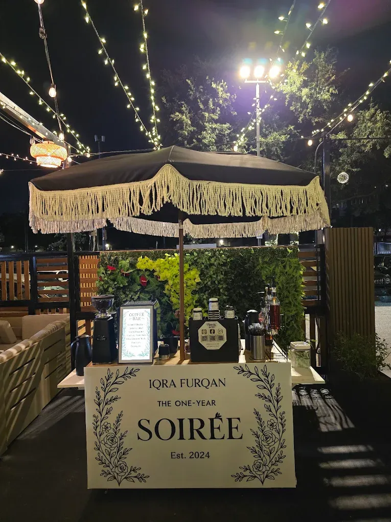 Cocktail bar with fringed umbrella, string lights, and a 