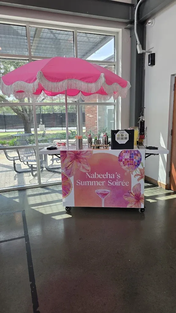 A pink and white decorated bar cart inside a building, 