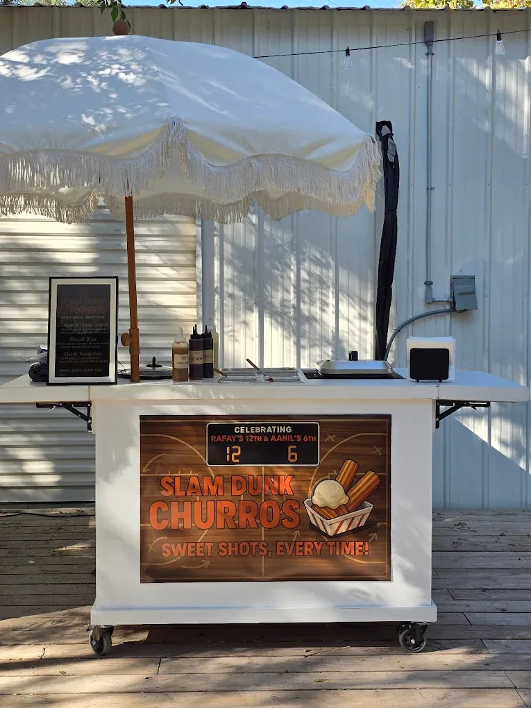 Churro stand with umbrella. White cart with logo 