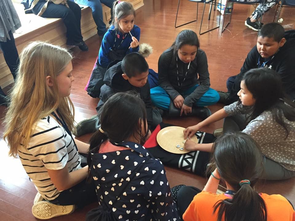 Children playing a traditional stick game together