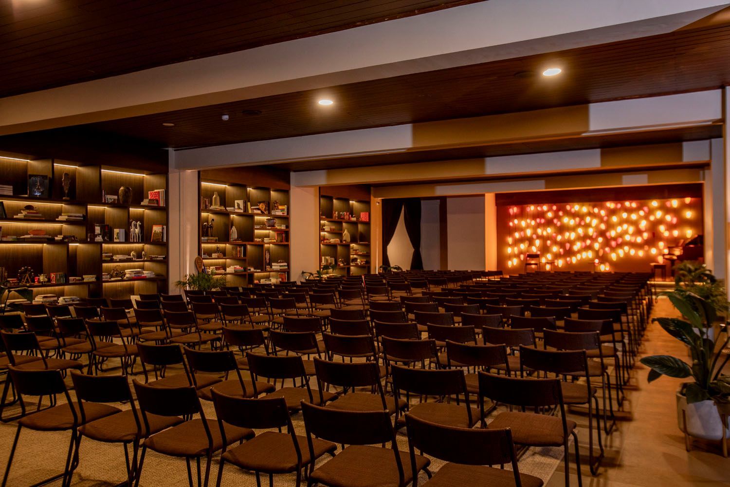 Uma sala grande com fileiras de cadeiras e um palco.