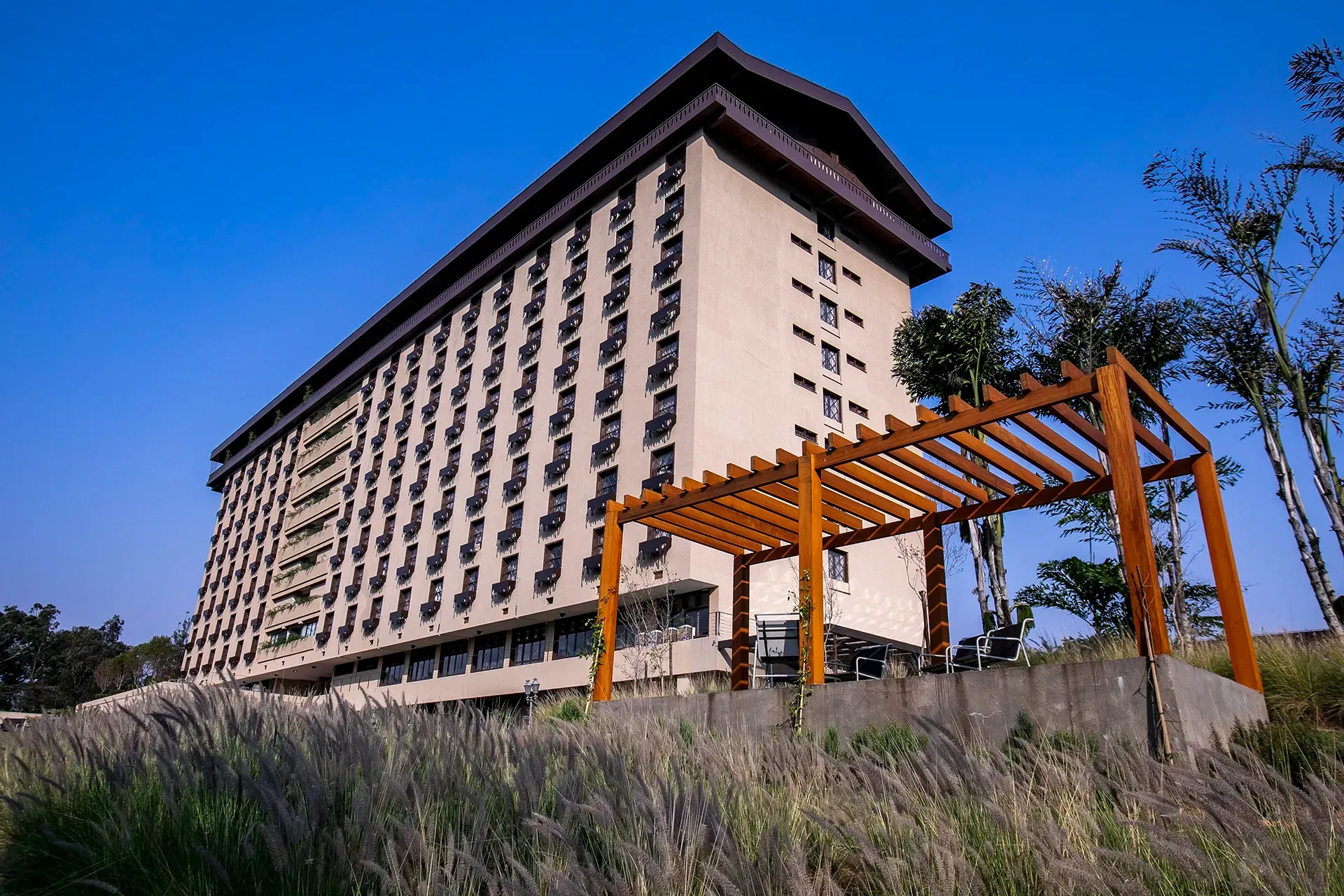 Um grande edifício com uma pérgola de madeira na frente.