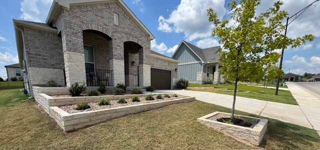 Modern home with brick facade, front yard with lawn, raised garden bed, tree, and sidewalk on a sunny day.