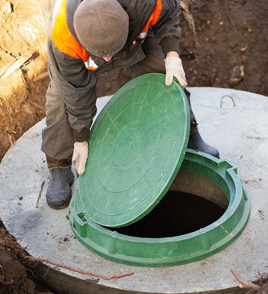 Worker Installs a Sewer Manhole on a Septic Tank — Crestview, FL — Madden Septic Service Worker Installs a Sewer Manhole on a Septic Tank — Crestview, FL — Madden Septic Service