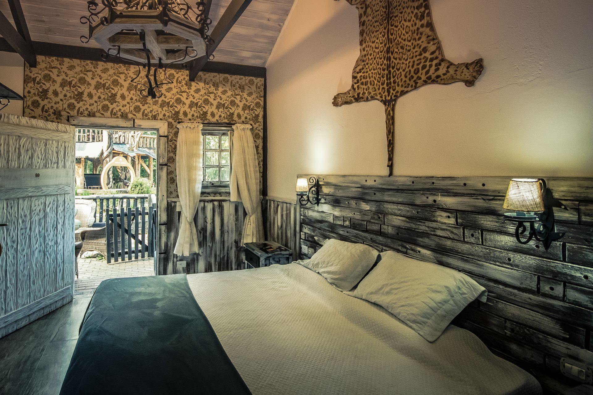 Um quarto com uma cama grande e uma estampa de leopardo na parede.
