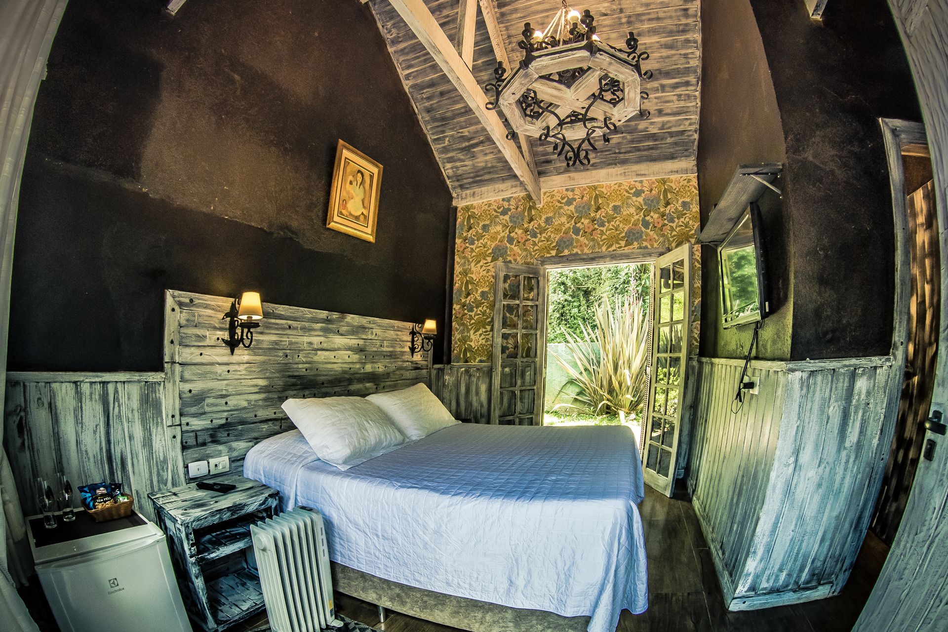 Um quarto com cama king size e lente olho de peixe.