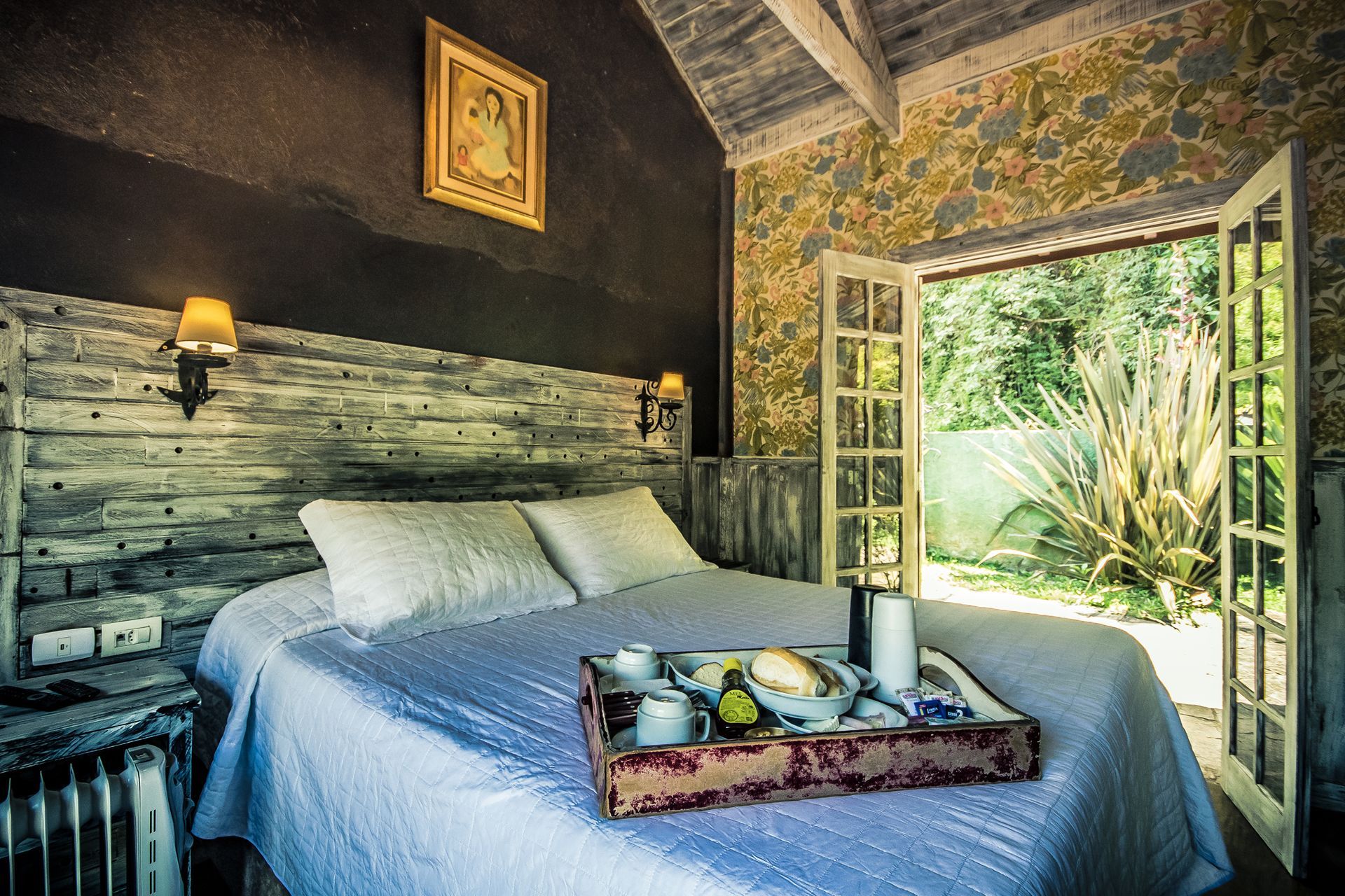 Um quarto com uma cama e uma bandeja de comida.